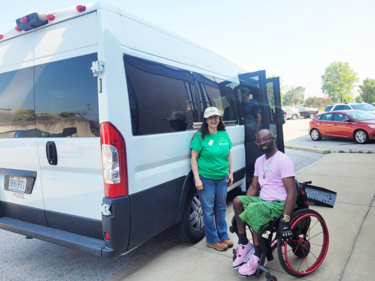 Two people in front of an accessible van