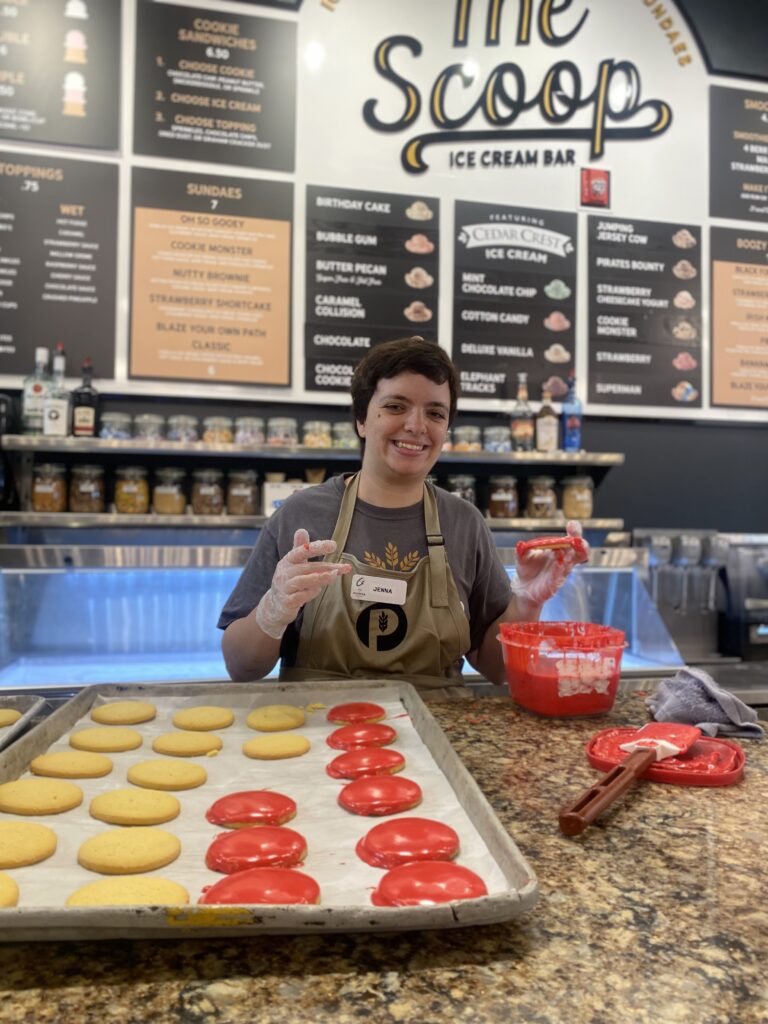 A person icing cookies at work